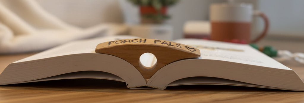 Wooden toy figure labeled 'Porch Pals' on an open book with a blurred background
