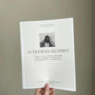 Close-up of a hand holding a business document titled 'Outsourcing Blueprint'.