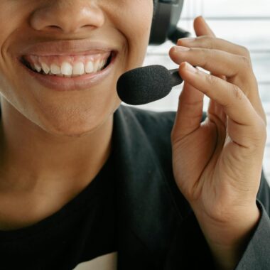 Close-up of a smiling call center representative holding a microphone.